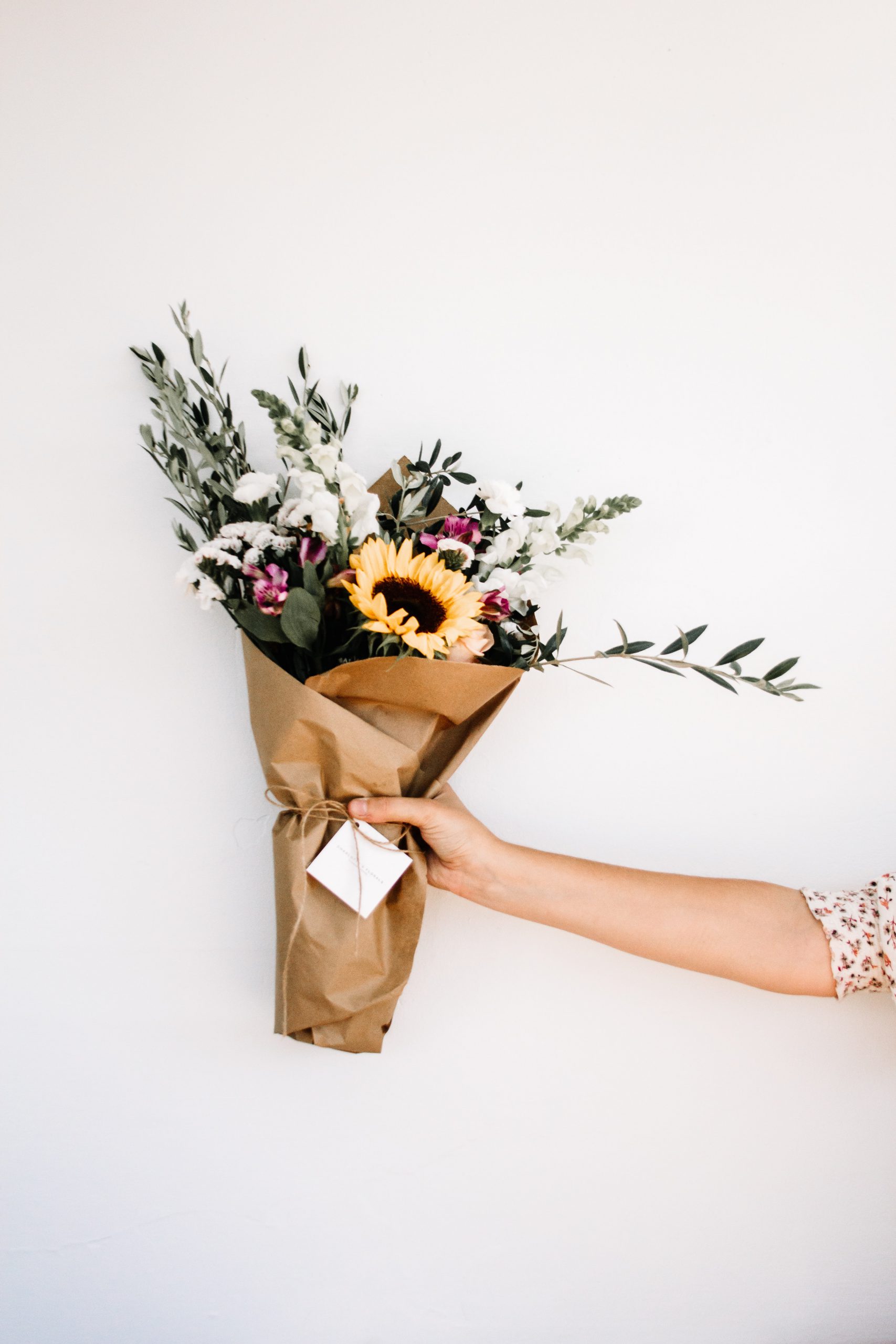 Person handing over bouquet of flowers